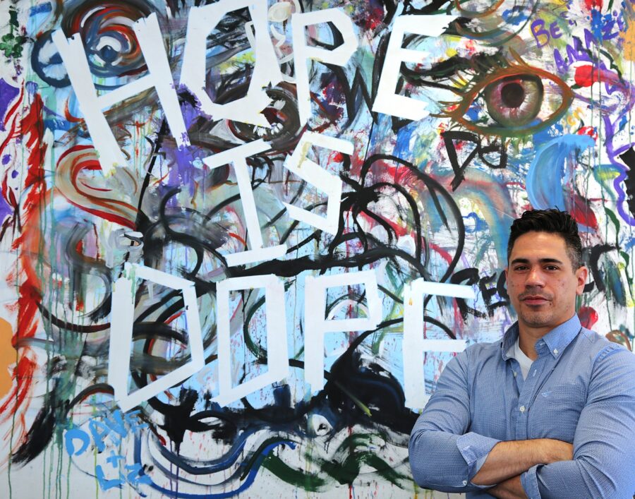 Ken Clowes, Community Initiatives Center assistant at Butler County Community College, is shown Monday, April 26, 2021, in BC3’s office in downtown Butler with a Hope is Dope painting created by participants who attended a college Hope Night in May 2019. BC3 has announced five upcoming Hope Nights through September in downtown Butler.