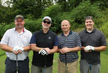 This is a portrait of Farmers National Bank team at BC3 Education Foundation golf outing. There are four golfers in the photo.