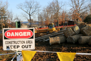 bulldozer behind DANGER construction keep out sign