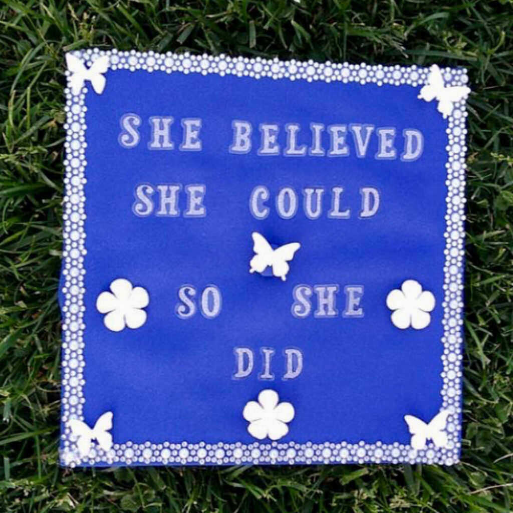 blue grad cap with design "She believed she could, so she did.”