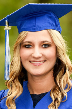portrait of blonde female bc3 graduate in cap and gown