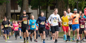 runners on wearing race bibs with numbers at a fall 5k at bc3
