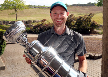 male golfer holding trophy resembling stanley cup but is actually BC3 Golf Outing Trophy